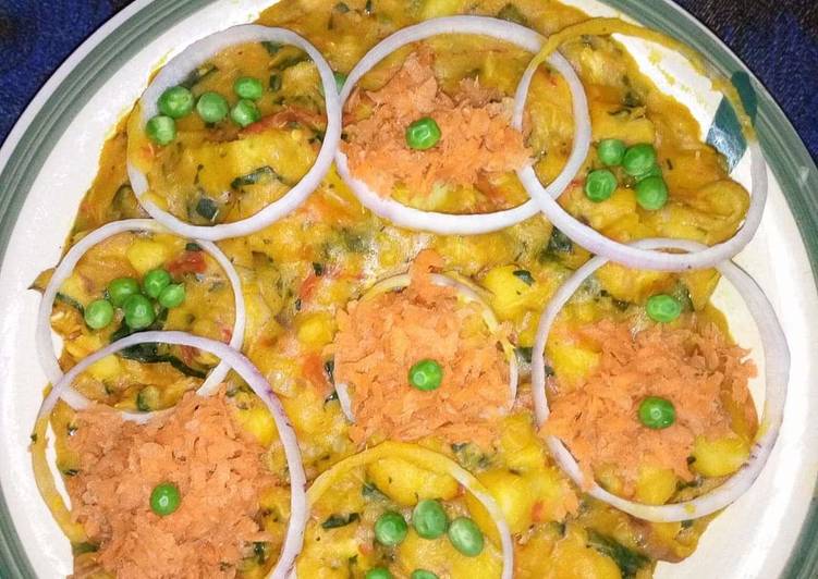 Yam porridge garnish with grated carrots, onions and peas