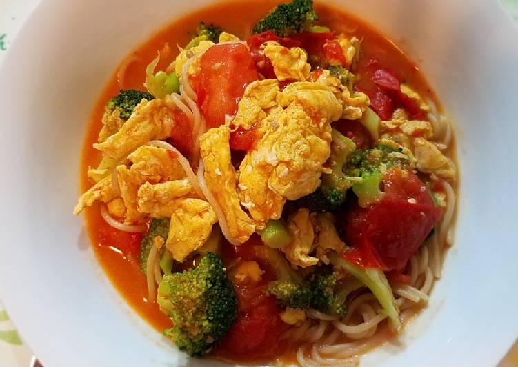 Scrambled eggs, broccoli and tomatoes over pasta
