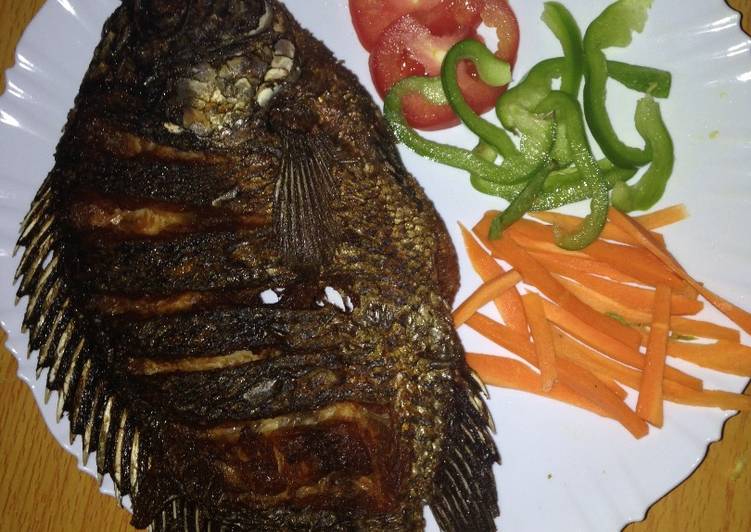 Deep fried fish garnished with green pepper, carrots and tomatoes