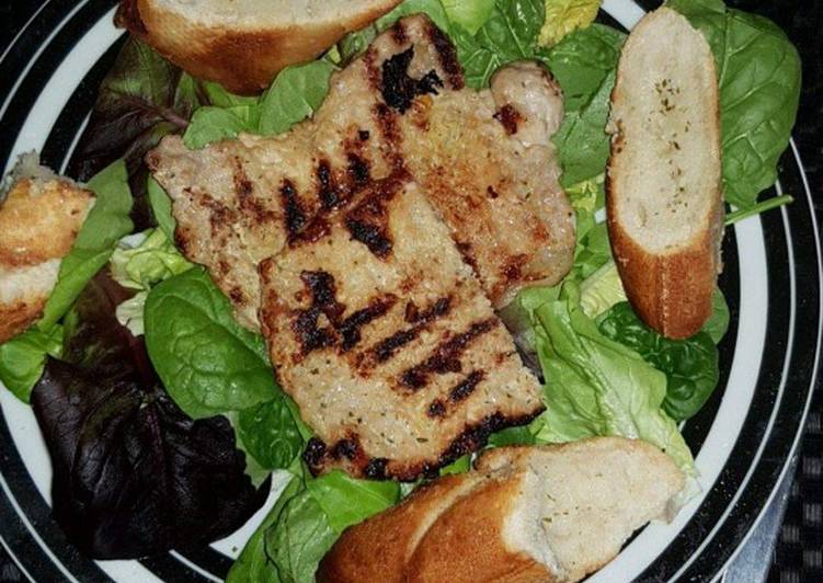 Grilled pork with salad and garlic bread